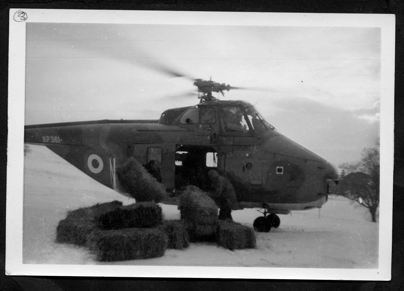Coll. Sheila Bryant
Les Bryant pulls hay from RAF helicopter towards the end of the  '63 snows.- Cow Gap Farm. Fodder had run out at steadings and many sheep were stuck out of reach on the fell.