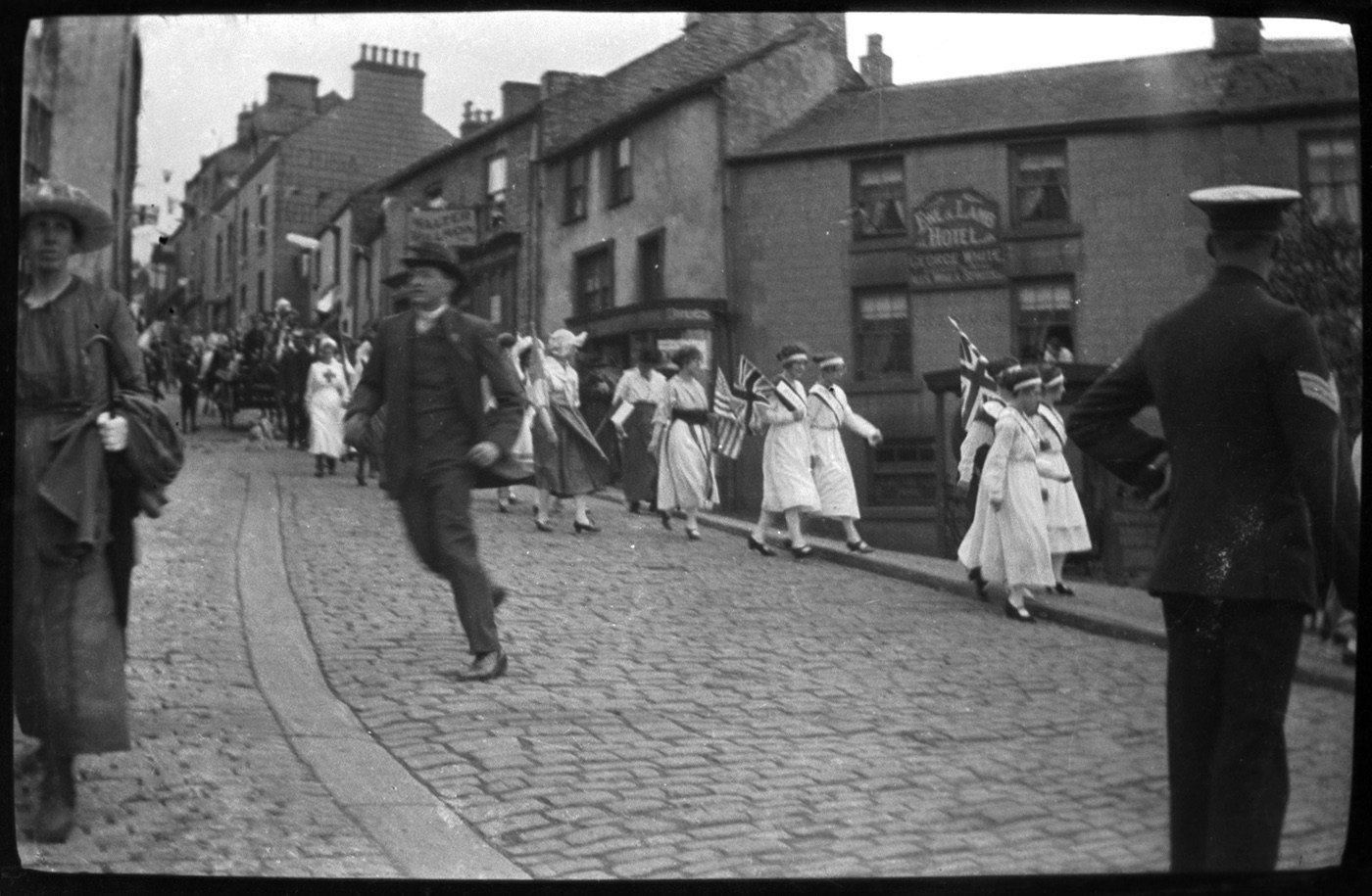 Coll. Jack Douglas 1 Park View Lane, Alston CA9 3TW Tel 381795. Copied into archive with permission Nov 2009.
1919 Peace Celebrations in Alston- July 19th
These photographs were probably taken by Jack's father, Mark.
George White in the Ewe and Lamb, Alston Drug Company, Walter Willson's and the Victoria Hotel all showing.
A man with gloved? hand runs from the gathering parade. A dog barks at the float driven by John Willie Cousin.