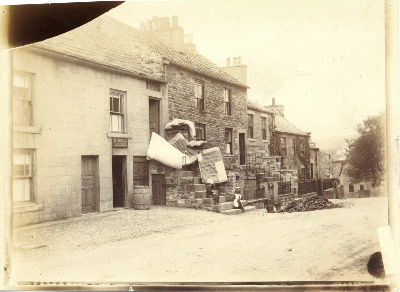 
Spring Cleaning at Alston. H. Bell is a grocer but it's the folk upstairs who've put the mattresses out beside the old chapel.
From the scuttles beside it, that looks like coal- delivered the rough way!