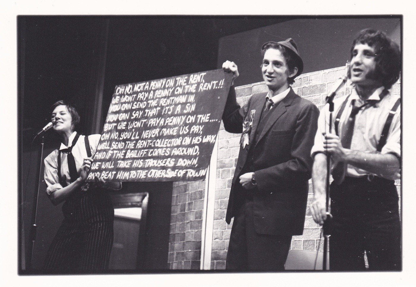 7:84  a radical leftist theatre group, (name derived from the fact that 7% of the world own 84% of its wealth), wrote this play/theatrical experience based on the "demolition" of the CDP & its projects by the combined forces of the Conservative Party-dominated Cumbria County Council hand in hand with the Freemasons in the town. It was performed in the Civic Centre. To the right is Brian Hibbard, later to be front singer in The Flying Pickets and to star in the soap opera Coronation Street.